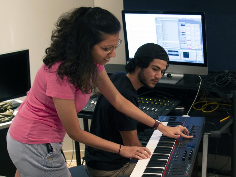 School of Music students work on a keyboard and computer program.