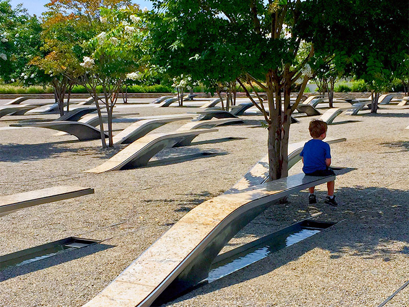 A child sits on a cantilever bench at the 9/11 Pentagon Memorial.