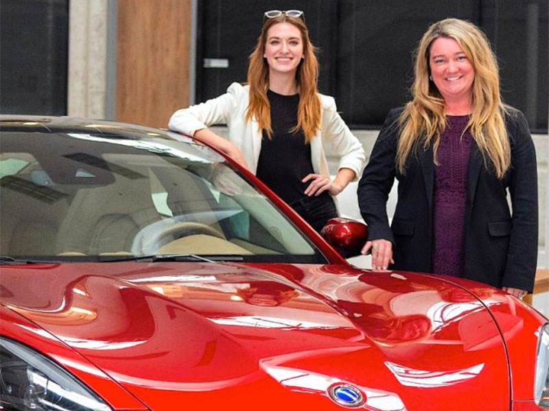 Industrial Design alumnae stand by a car