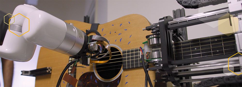 A robot arm plays a guitar