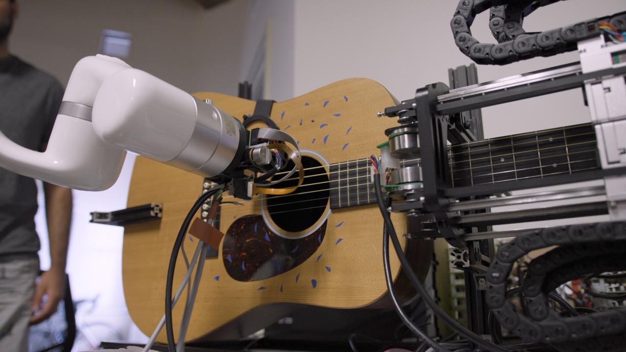 Robot arm playing an acoustic guitar