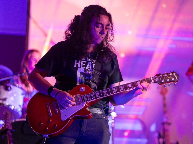 Student playing electric guitar in West Village 175 performance space