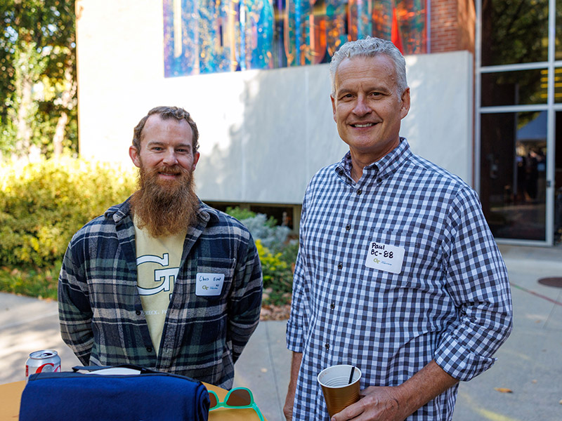 Alumni pose for a photo in front of the Design Sign on the East Architecture building