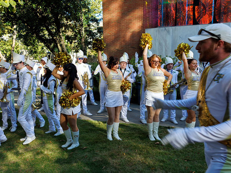 The Georgia Tech Yellow Jacket Marching Band and cheerleaders in front of the East Architecture building