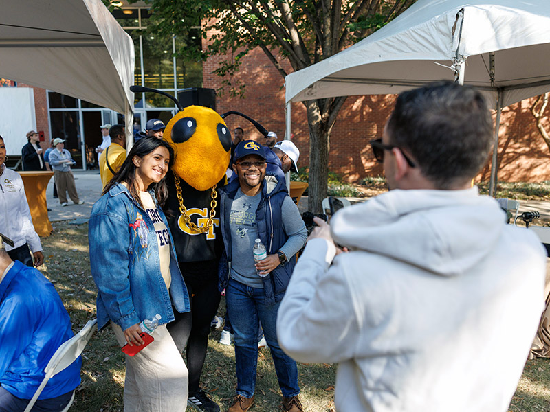 Alumni pose with Georgia Tech mascott Buzz